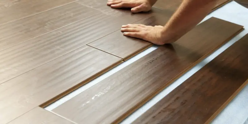 A person is installing a new wood floor